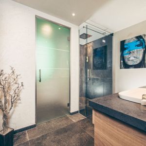 Badezimmer mit begehbarer Dusche in der Apartmentsuite im Hotel Bergkristall Hippach